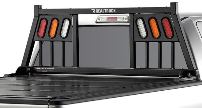 BackRack Three Light: black Three Light headache rack with three light openings mounted behind the cab of a pickup, seen from the rear quarter