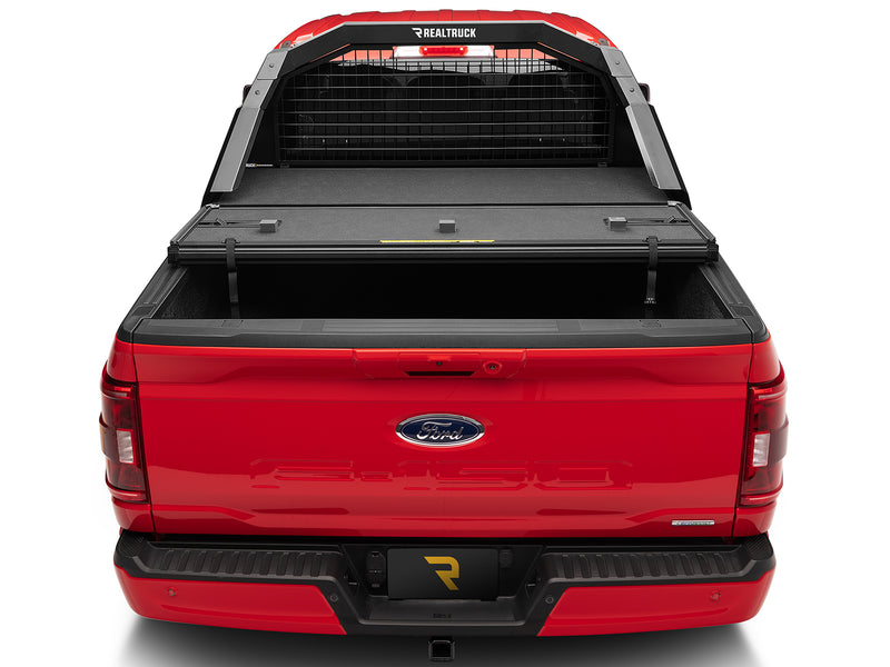 BackRack Trace Rack: rear view of a red Ford F-150 with a black Trace Rack and a tonneau cover folded forward