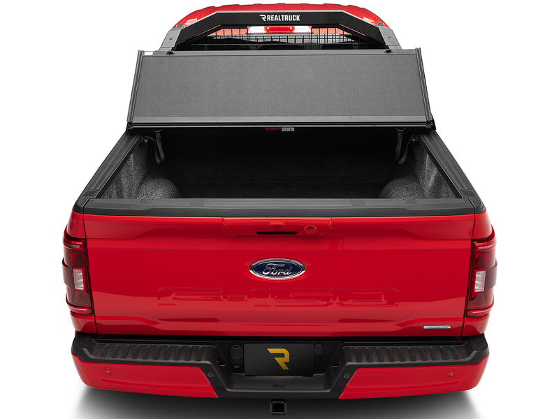 BackRack Trace Rack: rear view of a red Ford F-150 with a black rack behind the cab and a tonneau cover partly opened