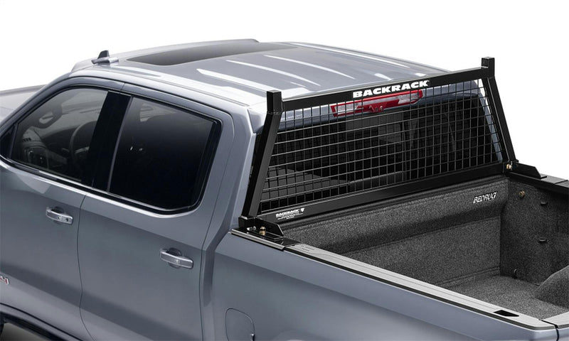 BackRack Utility Body Safety: A black mesh headache rack mounted behind the cab of a silver pickup with a carpeted bed liner