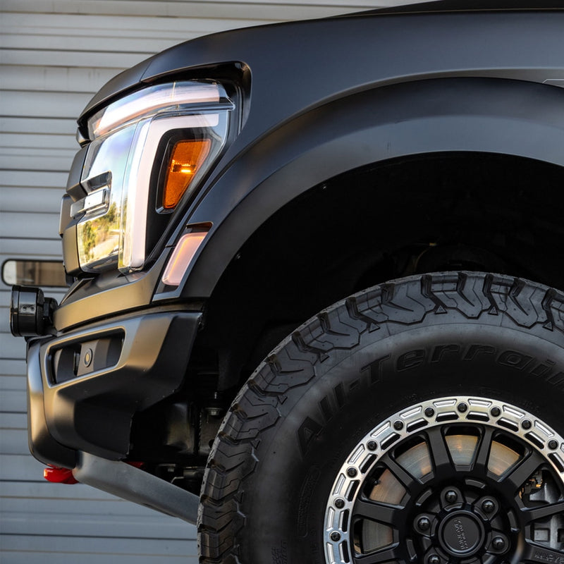 Baja Designs 6 XL Linkable Bumper Light Kit on a Ford F-150: low side view of a black Ford pickup front fender, headlight and all-terrain tire, with the light kit barely visible at the bumper edge