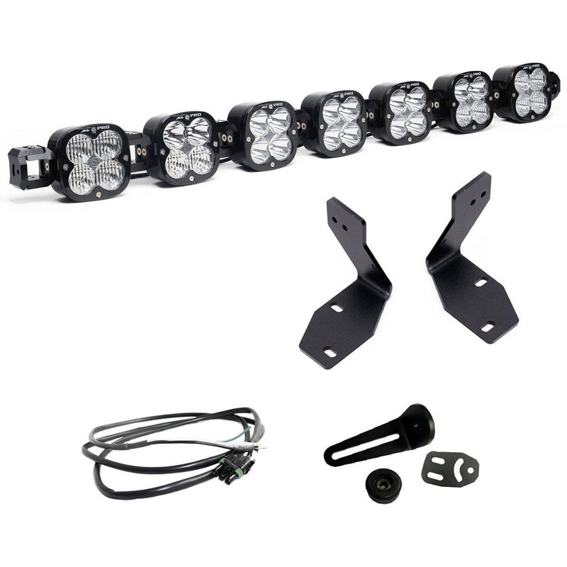 Baja Designs 7XL Linkable Bumper Light Kit, complete kit on a studio background: A seven-pod XL Linkable light bar kit on white with two tall bumper brackets, a small pod mount with hardware and a short pigtail harness