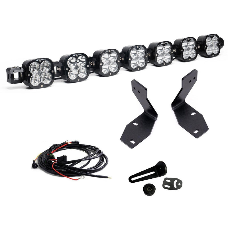 Baja Designs 7XL Linkable Bumper Light Kit, complete kit on a studio background: A seven-pod XL Linkable light bar kit on white with two tall bumper brackets, a small pod mount with hardware and a relay wiring harness