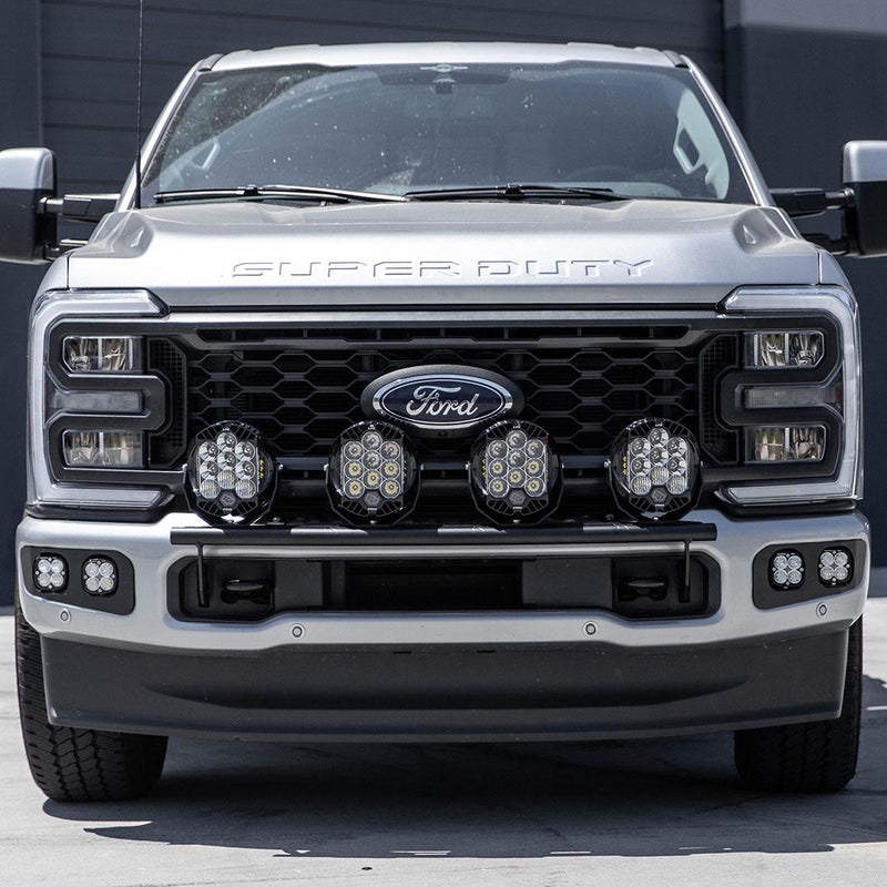 Baja Designs Bull Bar Light Kit installed on a Ford F-250/F-350 Super Duty: the front of a silver Ford Super Duty with four round LED pods on a black bull bar