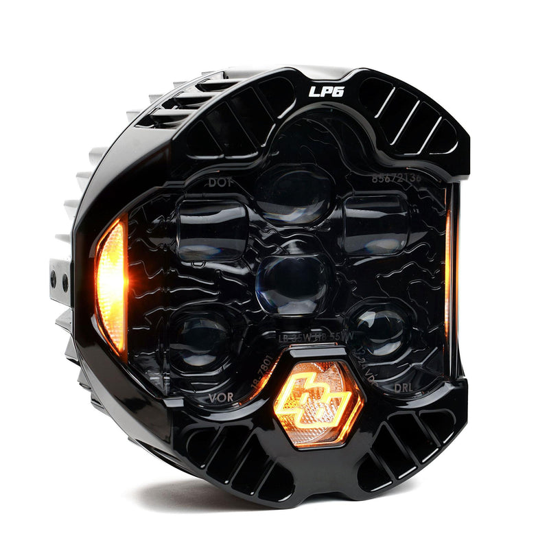 Baja Designs DOT LP6 LED Headlight Replacement, whole product on a studio background: A single LP6 LED headlight with a clear lens and amber accent light glowing, on white