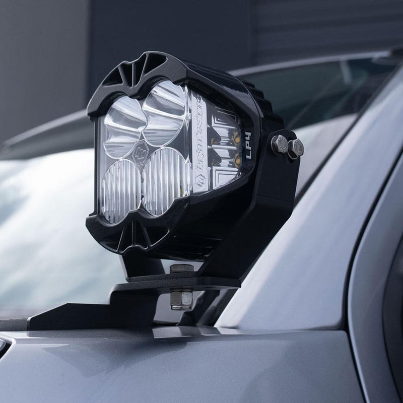 Baja Designs LP4 A-Pillar Light Kit on a vehicle: A Baja Designs LP4 LED pod mounted on an A-pillar bracket beside the windshield of a silver gray truck
