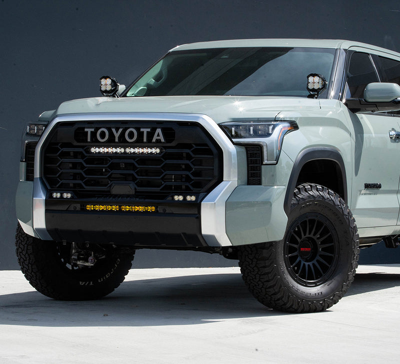 Baja Designs LP4 Pro A-Pillar Light Kit installed on a Toyota Tundra: A sage green Toyota Tundra with TOYOTA grille lettering, LED pods on both A-pillars and a light bar in the lower bumper