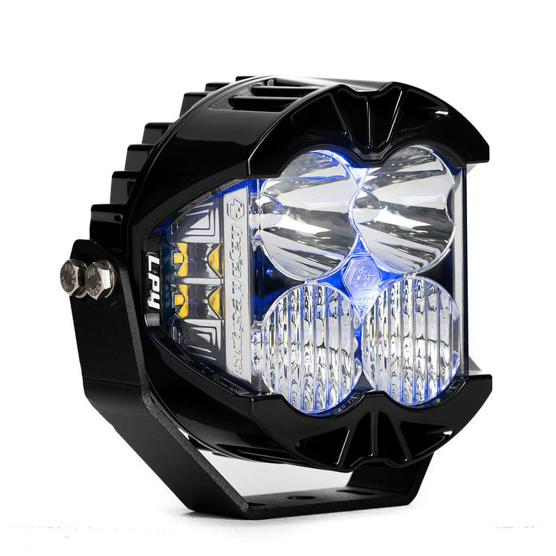 Baja Designs LP4 Pro LED Auxiliary Light Pod, whole product on a studio background: A black LP4 Pro LED pod with clear lenses and a blue colored backlight glowing, shown at an angle on white