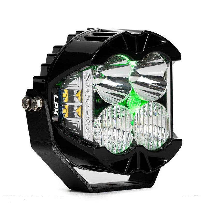 Baja Designs LP4 Pro LED Auxiliary Light Pod, whole product on a studio background: A black LP4 Pro LED pod with clear lenses and a green colored backlight glowing, shown at an angle on white
