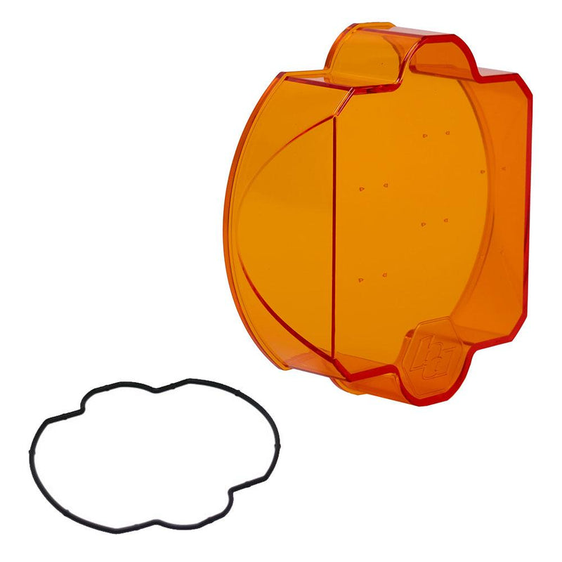 Baja Designs LP9 Light Pod Lens Kit, complete kit on a studio background: A orange LP9 replacement lens cover with smooth optics and a black rubber gasket on a white background
