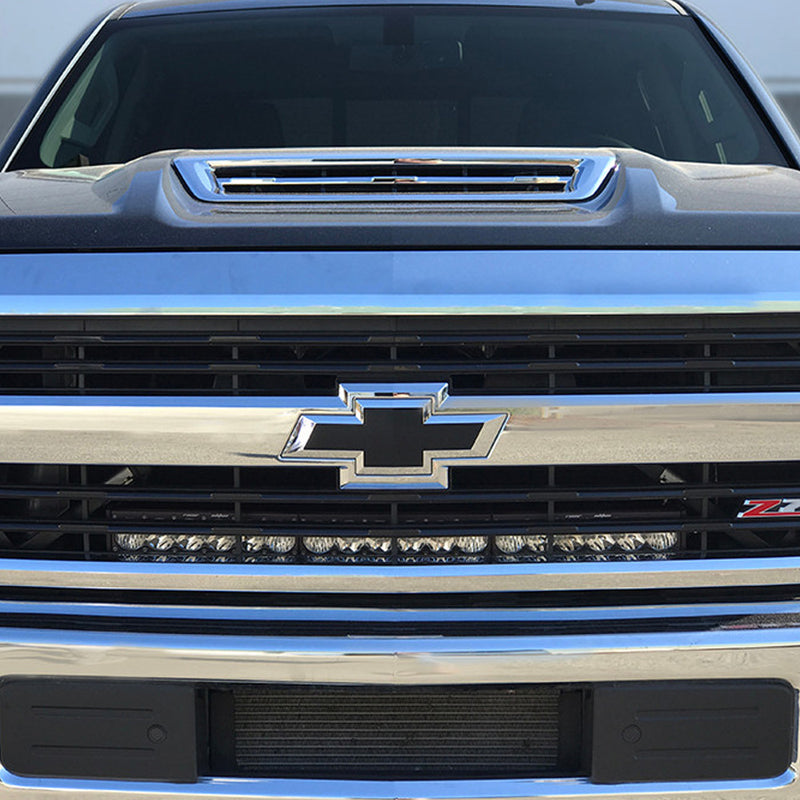 Baja Designs OnX6+ 30" Grille Light Bar Kit on a Chevrolet Silverado HD: chrome Chevrolet Silverado HD grille with a long LED light bar fitted across the lower grille opening below the bowtie