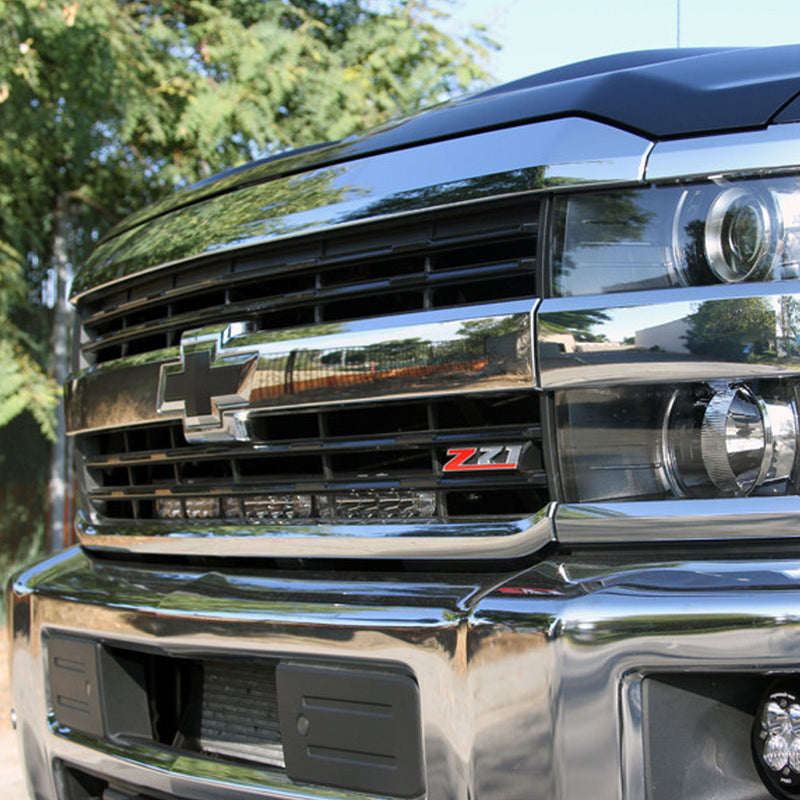 Baja Designs OnX6+ 30" Grille Light Bar Kit on a Chevrolet Silverado HD: front three-quarter view of a Chevrolet Silverado grille with a Z71 badge and a long LED light bar tucked into the lower grille