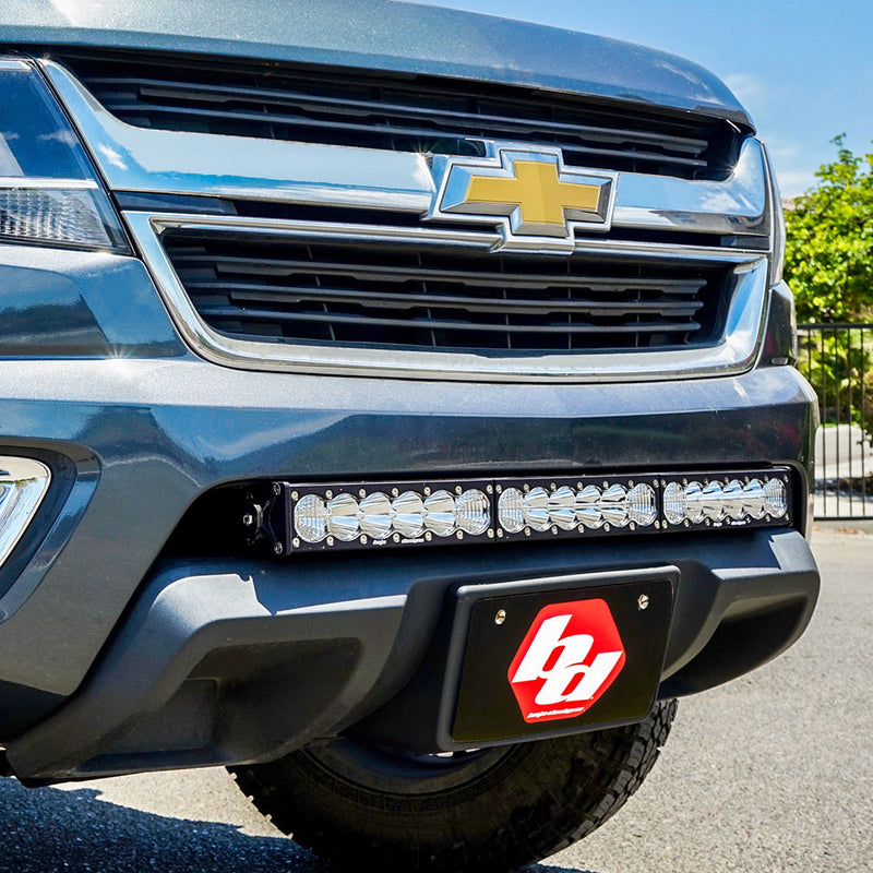 Baja Designs OnX6+ 30" Grille Lower Light Bar Kit on a Chevrolet Colorado: blue Chevrolet Colorado with a long LED light bar mounted in the lower bumper opening above a Baja Designs logo front plate