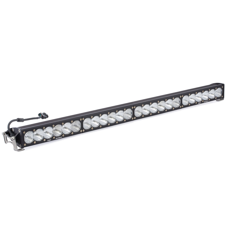 Baja Designs OnX6+ Straight LED Light Bar, whole product on a studio background: long black LED light bar with clear lenses, a wiring pigtail and end brackets on a white background
