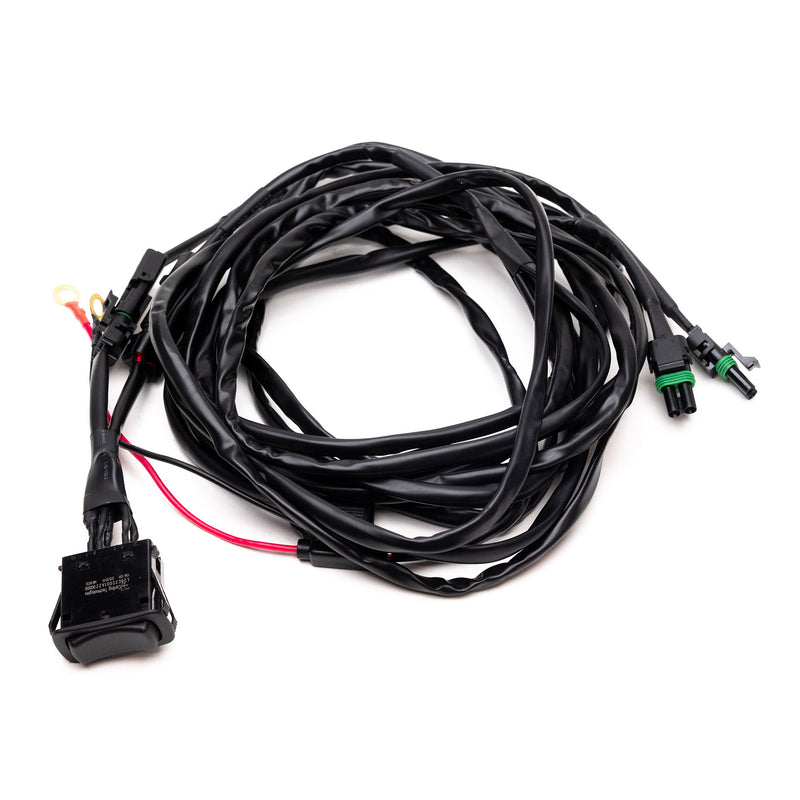 Baja Designs REFLEX Light Actuator Harness, Rocker Switch Universal Motor Actuator Adaptor Harness, whole product on a studio background: A long black actuator harness with a rocker switch, weatherpack connectors and a red power lead on white