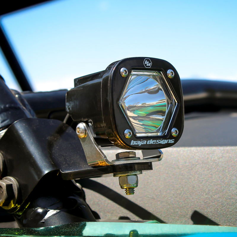 Baja Designs S1 Black LED Auxiliary Light Pod Pair on a vehicle: A black S1 light pod with a clear reflector lens bolted to a tube mount on an off-road vehicle in sunlight