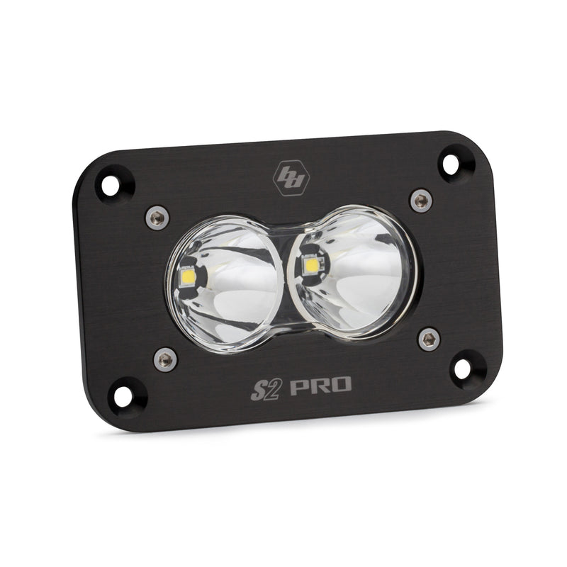 Baja Designs S2 Pro Black Flush Mount LED Auxiliary Light Pod, whole product on a studio background: A black S2 Pro flush mount LED pod with a clear spot lens and a flat mounting flange