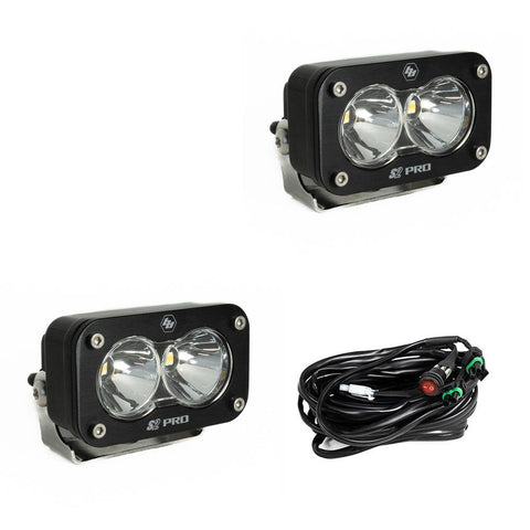 Baja Designs S2 Pro Black LED Auxiliary Light Pod Pair, whole product on a studio background: two black S2 Pro LED pods with clear smooth spot reflector lenses and a wiring harness with switch on a white background