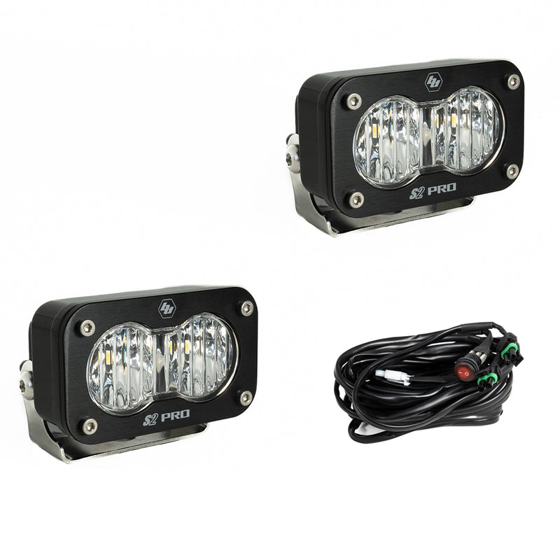 Baja Designs S2 Pro Black LED Auxiliary Light Pod Pair, whole product on a studio background: two black S2 Pro LED pods with clear fluted driving combo style lenses and a wiring harness with switch on a white background
