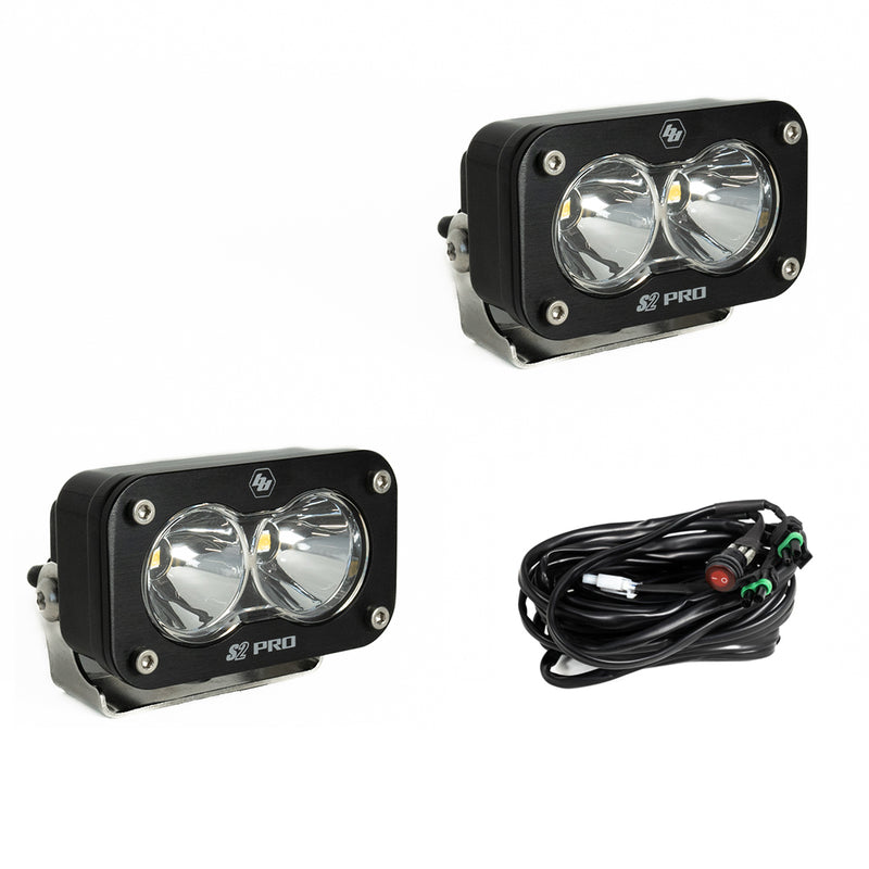 Baja Designs S2 Pro Black LED Auxiliary Light Pod Pair, whole product on a studio background: two black S2 Pro LED pods with clear smooth spot reflector lenses and a wiring harness with switch on a white background