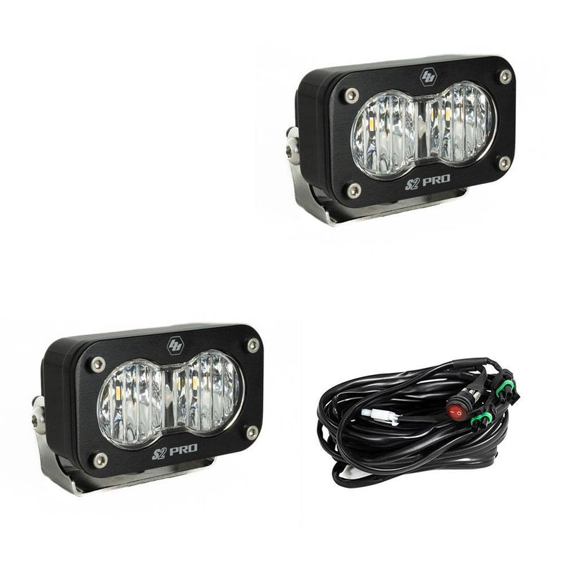 Baja Designs S2 Pro Black LED Auxiliary Light Pod Pair, whole product on a studio background: two black S2 Pro LED pods with clear fluted driving combo style lenses and a wiring harness with switch on a white background