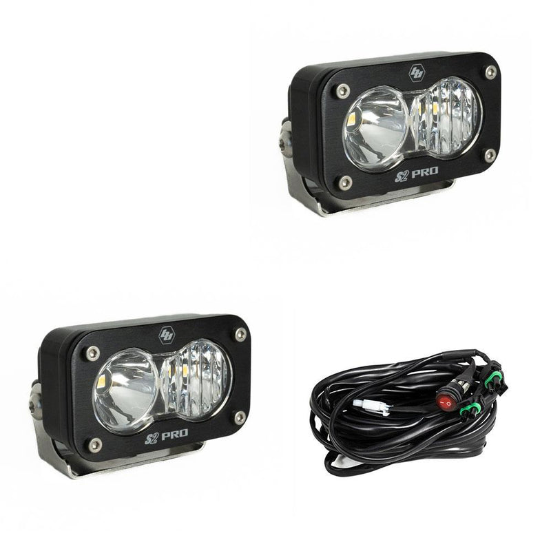Baja Designs S2 Pro Black LED Auxiliary Light Pod Pair, whole product on a studio background: two black S2 Pro LED pods with clear smooth spot reflector and fluted lenses and a wiring harness with switch on a white background