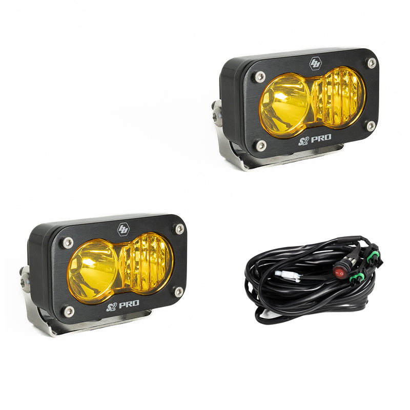 Baja Designs S2 Pro Black LED Auxiliary Light Pod Pair, whole product on a studio background: two black S2 Pro LED pods with amber fluted driving combo style lenses and a wiring harness with switch on a white background