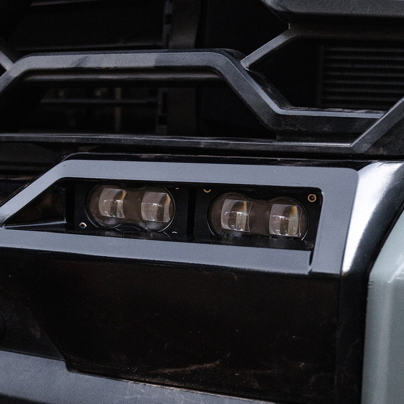 Baja Designs S2 SAE OEM Fog Light Replacement Kit on a Toyota Tundra/Sequoia: two S2 pods with clear lenses mounted in the lower bumper fog opening of a gray Toyota