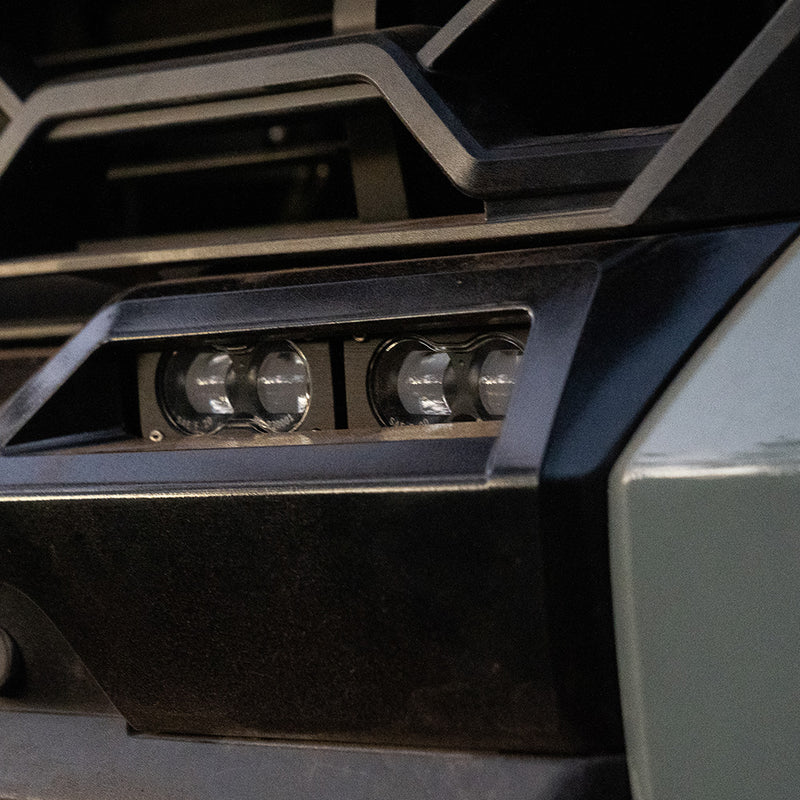 Baja Designs S2 SAE OEM Fog Light Replacement Kit on a Toyota Tundra: two S2 pods with clear lenses mounted in the lower bumper fog opening of a gray Toyota Tundra
