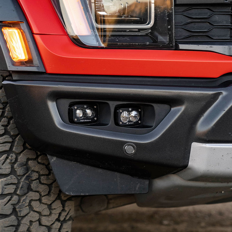 Baja Designs S2 SAE/S2 Sport Fog Pocket Kit on a Ford F-150 Raptor: close view of a red Ford Raptor front bumper with two unlit S2 pods in the fog pocket