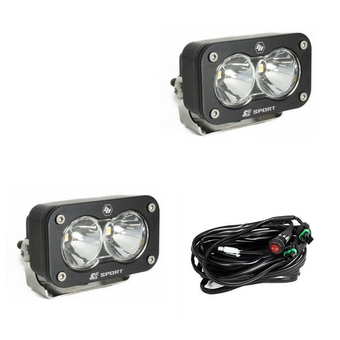 Baja Designs S2 Sport Black LED Auxiliary Light Pod Pair, whole product on a studio background: pair of black S2 Sport light pods with clear spot reflectors and a wiring harness on a white background
