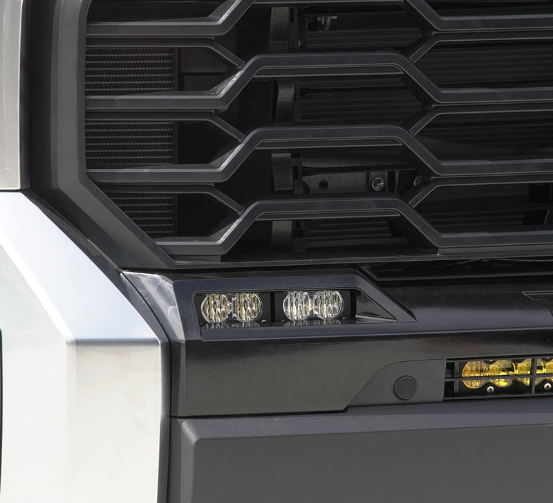 Baja Designs S2 Sport Dual Fog Pocket Light Kit on a Toyota Tundra: two S2 pods with clear lenses fitted in the lower fog opening beside the grille of a silver Toyota Tundra