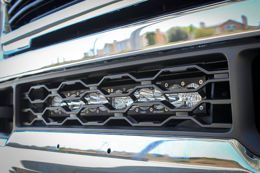 Baja Designs S8 20" Grille Lower Light Bar Kit on a Ram HD: close view of a chrome front bumper with an LED light bar fitted inside the lower grille opening