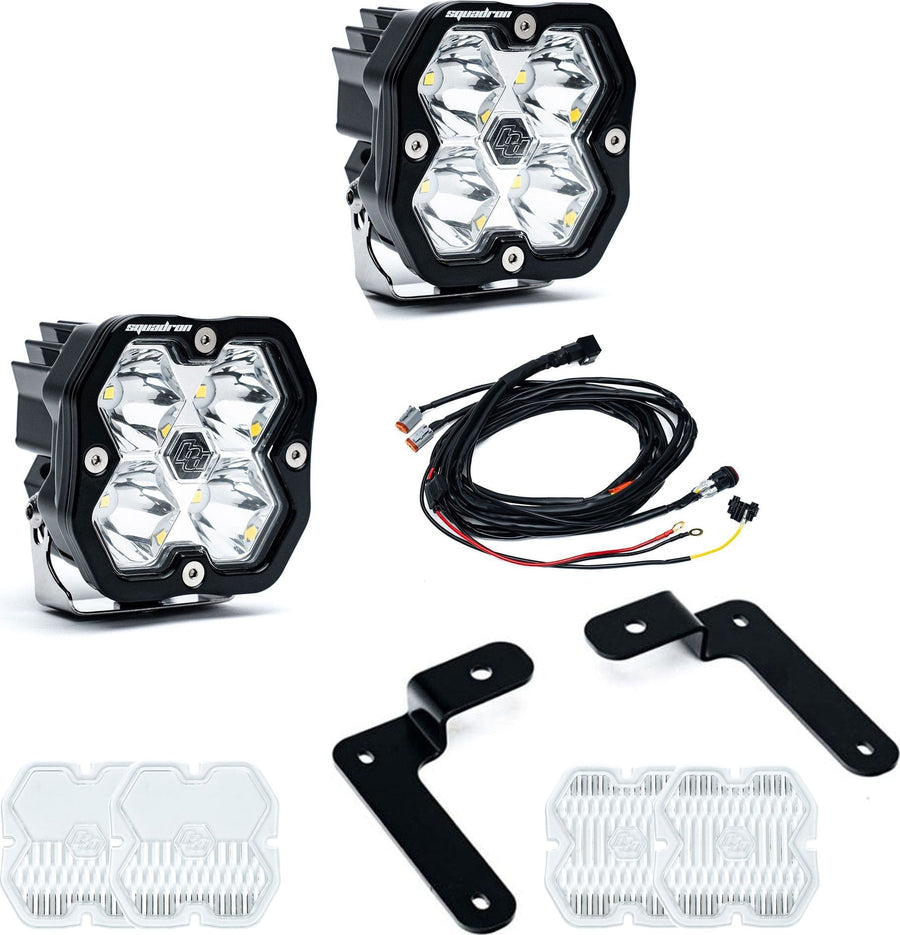 A-Pillar Light Kits by Baja Designs: Two Squadron Sport pods with black angled A-pillar brackets, a wiring harness and spare clear lens covers on white.