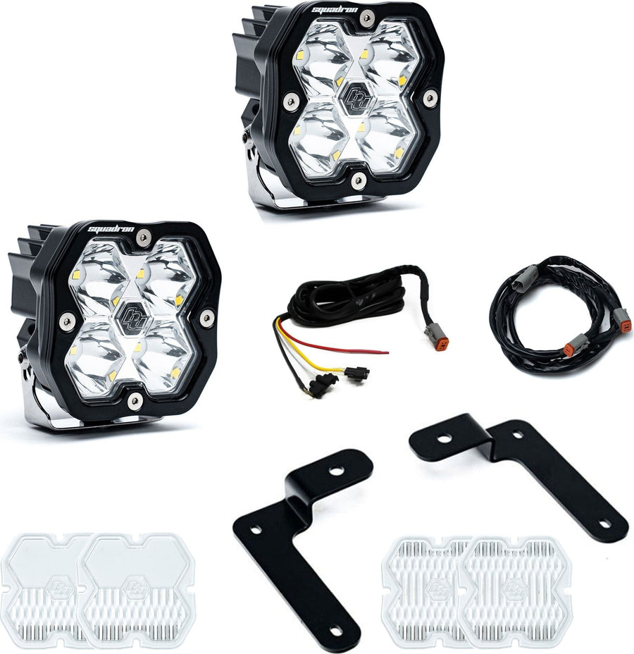A-Pillar Light Kits by Baja Designs: Two Squadron Sport pods with black angled A-pillar brackets, harness sections and spare clear lens covers on white.