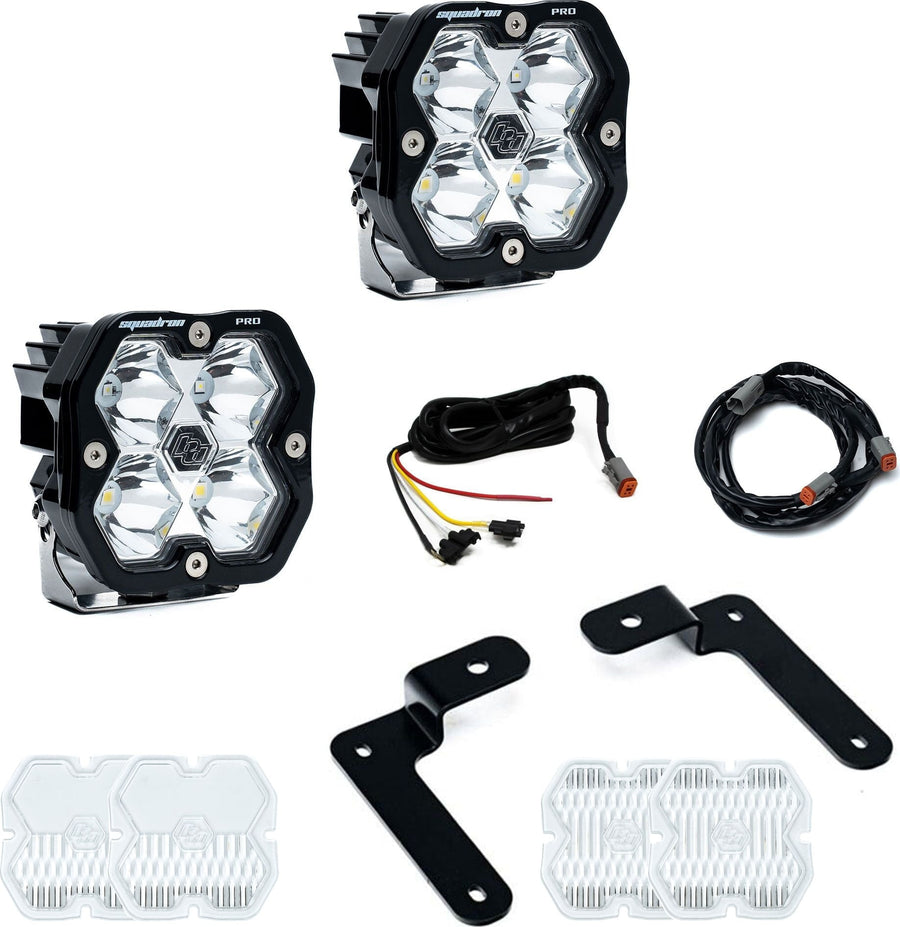 A-Pillar Light Kits by Baja Designs: Two Squadron Pro pods with black angled A-pillar brackets, two harness sections and spare clear lens covers on white.