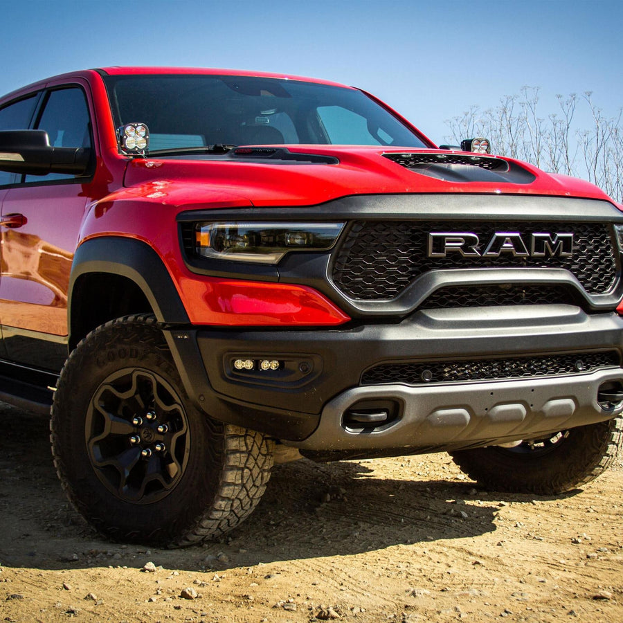 A-Pillar Light Kits by Baja Designs: A red Ram TRX pickup on dirt with a pair of light pods mounted at the A-pillars.