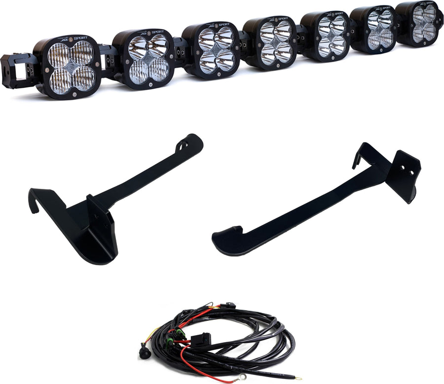 Bumper Light Kits by Baja Designs: Seven XL linkable pods joined as one bar with two long black mounting brackets and a wiring harness on white.