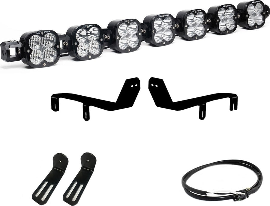 Bumper Light Kits by Baja Designs: A seven-pod XL Linkable light bar kit on white with two bumper brackets, two slotted mounts and a short coiled pigtail harness.