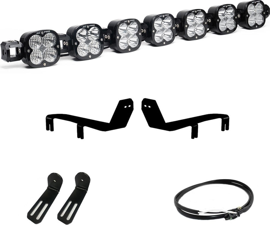 Bumper Light Kits by Baja Designs: A seven-pod XL Linkable light bar kit on white with two bumper brackets, two slotted mounts and a short coiled pigtail harness.