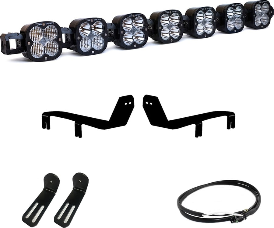 Bumper Light Kits by Baja Designs: A seven-pod XL Linkable light bar kit on white with two bumper brackets, two slotted mounts and a short coiled pigtail harness.