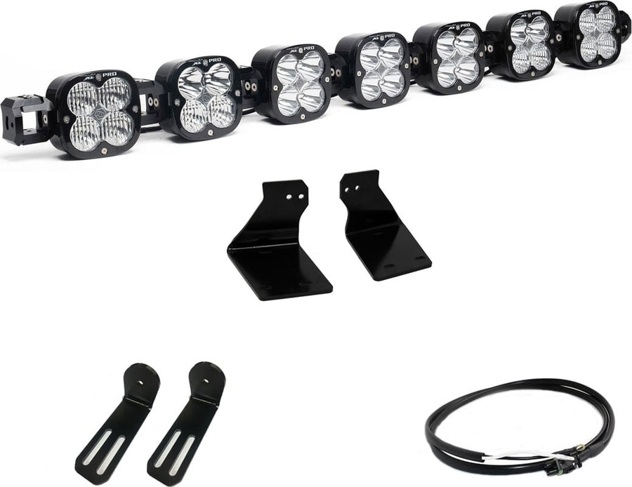 Bumper Light Kits by Baja Designs: A seven-pod XL Linkable light bar kit on white with two bumper brackets, two slotted mounts and a short coiled pigtail harness.