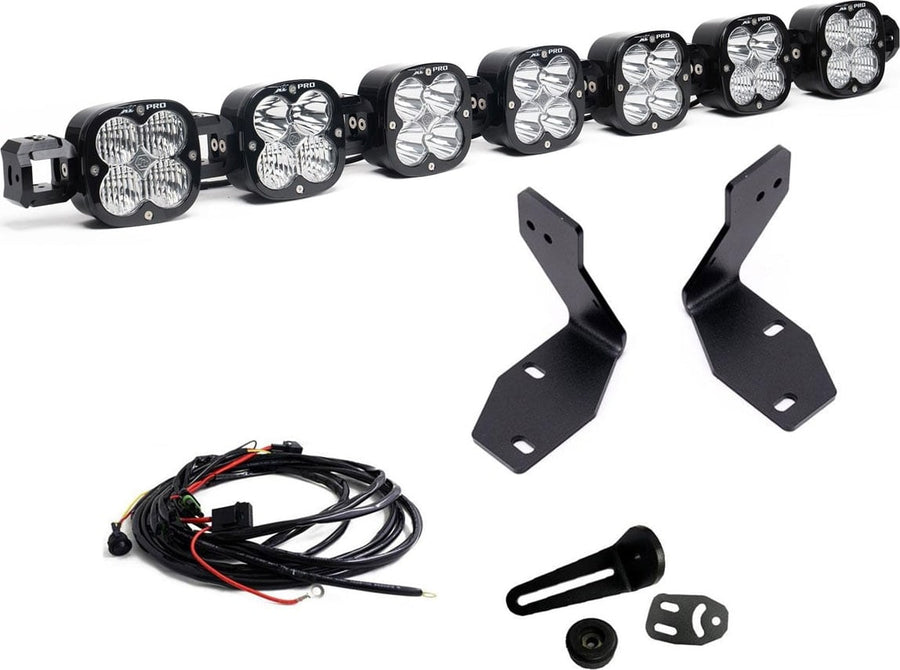Bumper Light Kits by Baja Designs: A seven-pod XL Linkable light bar kit on white with two tall bumper brackets, a small pod mount with hardware and a relay wiring harness.