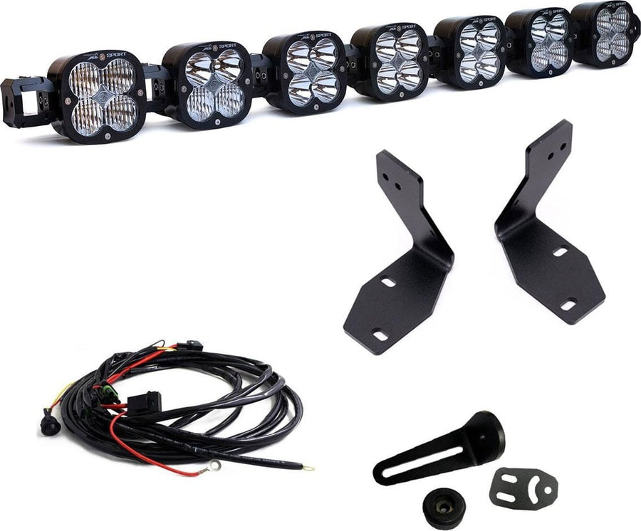 Bumper Light Kits by Baja Designs: A seven-pod XL Linkable light bar kit on white with two tall bumper brackets, a small pod mount with hardware and a relay wiring harness.