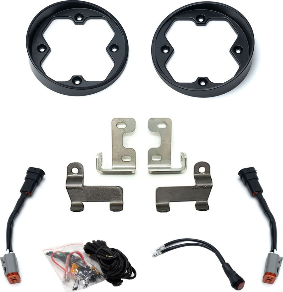 Fog Light Kits by Baja Designs: Fog pocket mount kit with two round black bezels, steel brackets, adapter harnesses, a pigtail and a hardware bag on white.
