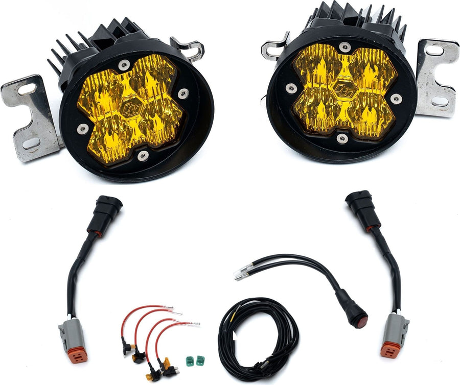 Fog Light Kits by Baja Designs: Pair of round amber lens fog pocket lights on steel brackets with adapter harnesses and wiring on white.