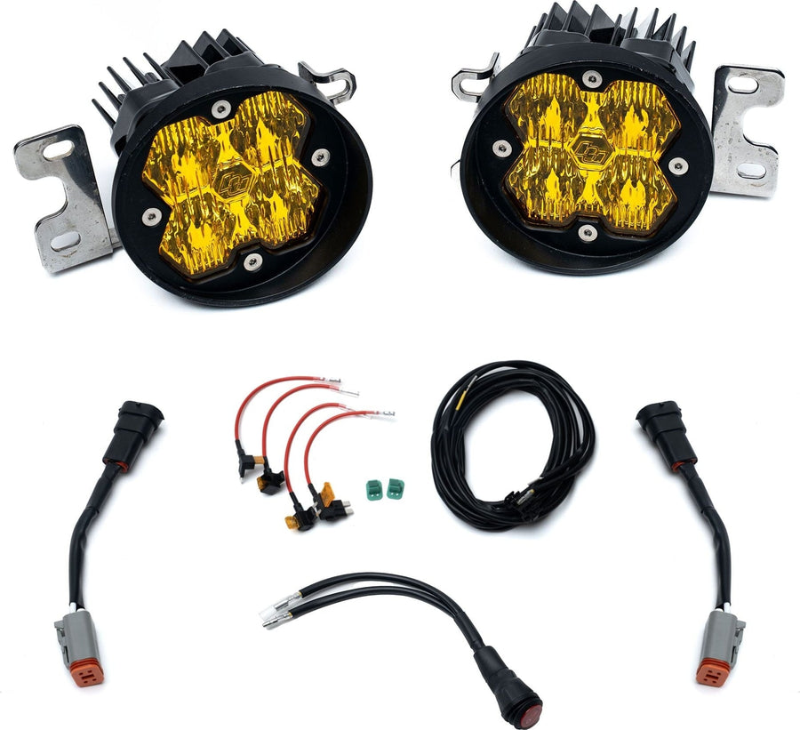 Fog Light Kits by Baja Designs: Pair of round amber lens fog pocket lights on steel brackets with adapter harnesses and wiring on white.