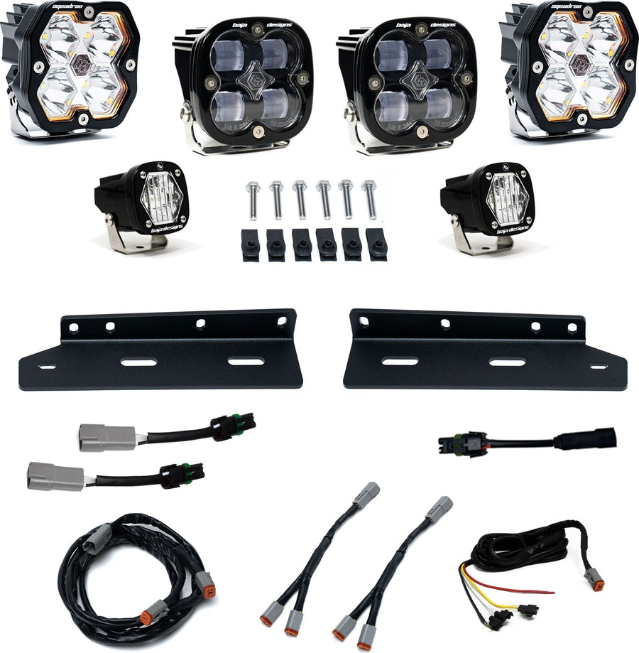 Fog Light Kits by Baja Designs: Fog pocket kit with two square Sport pods, two SAE fog pods, two small S1 pods, brackets, bolts and harnesses on white.