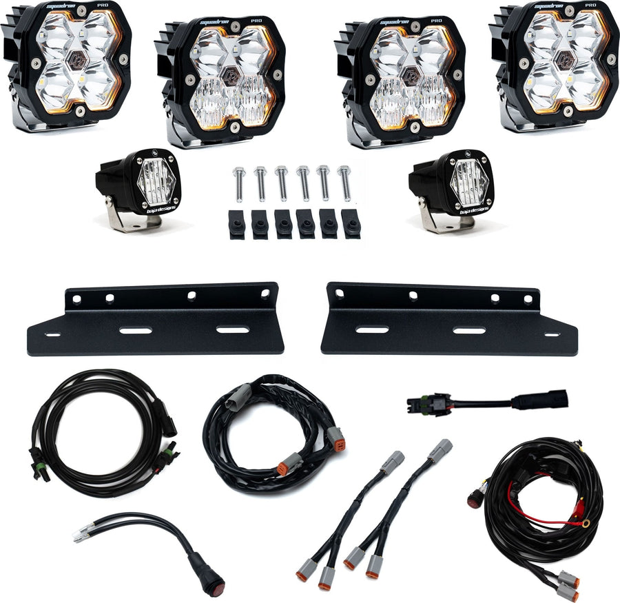 Fog Light Kits by Baja Designs: Fog pocket kit with four square Squadron Pro pods, two small S1 pods, brackets, bolts and wiring harnesses on white.