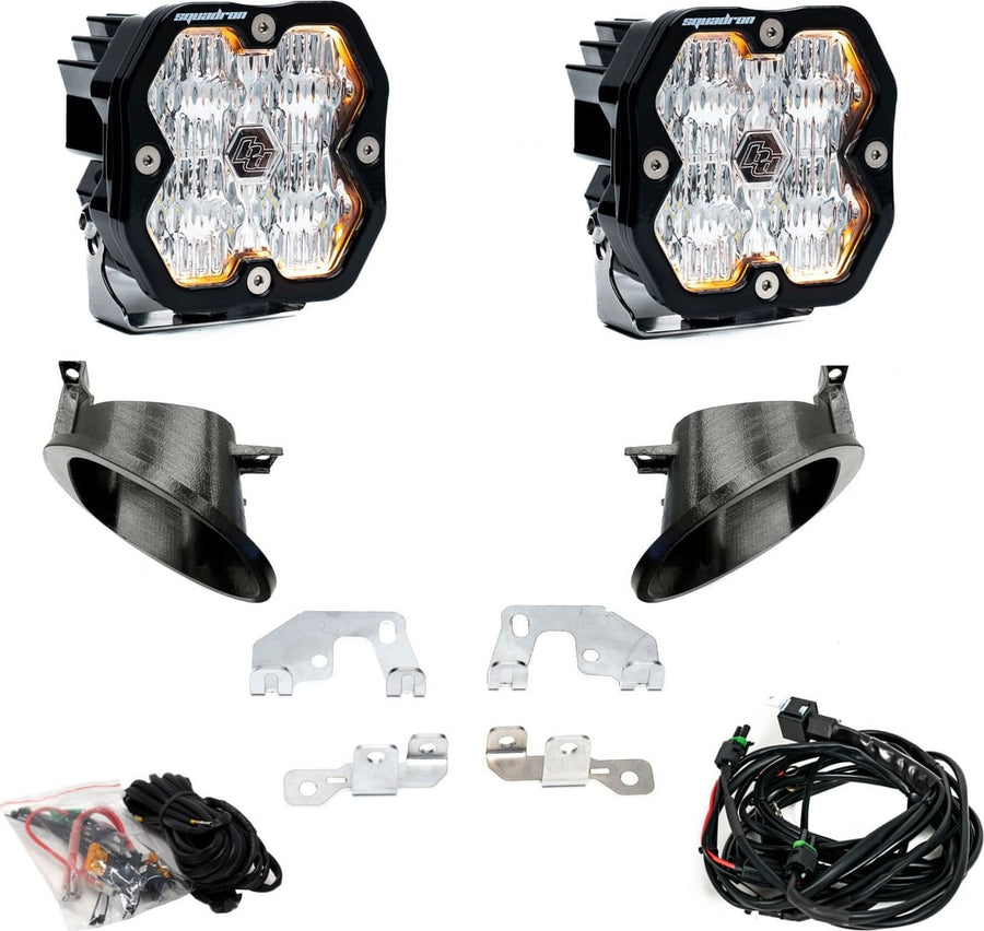 Fog Light Kits by Baja Designs: Fog pocket kit with two square clear lens pods, two black bezel cups, steel brackets, hardware and a harness on white.